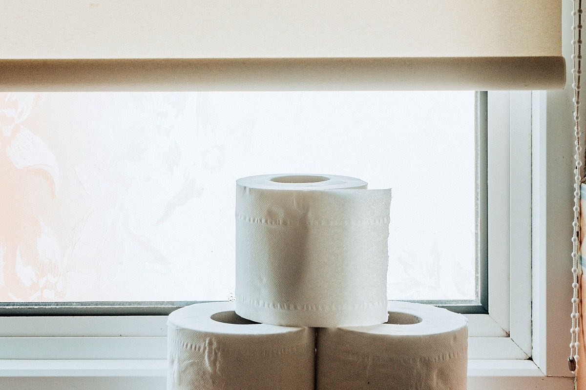 Three toilet paper rolls on a bathroom windowsill.